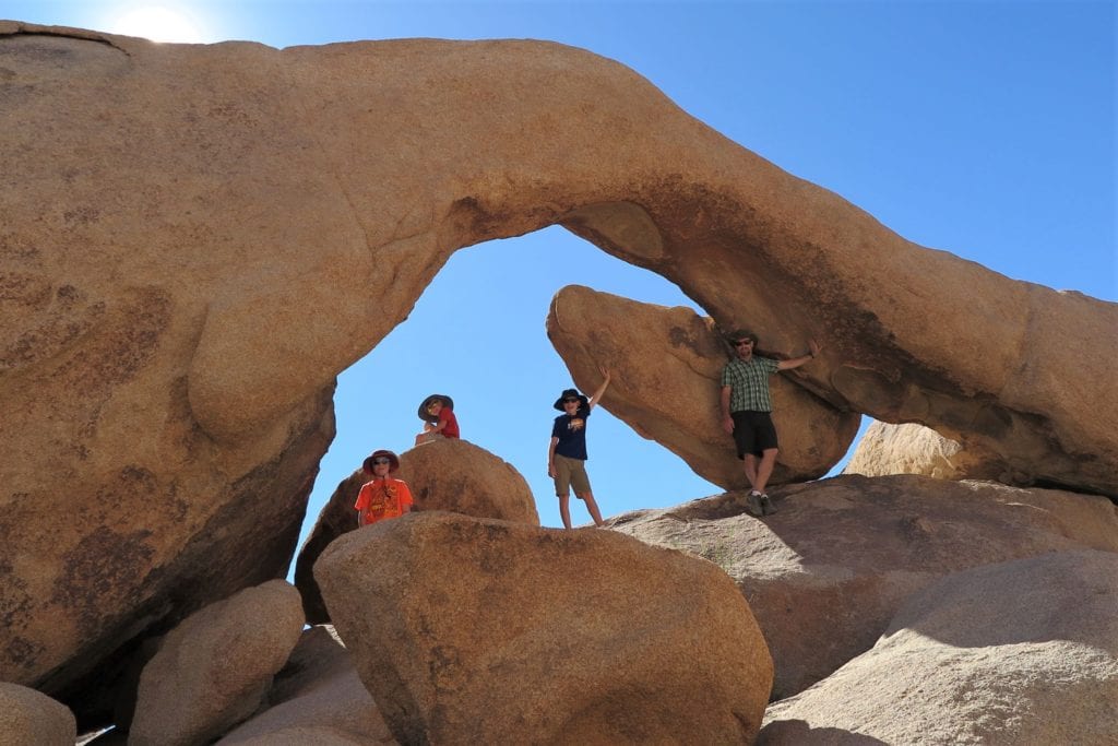 Standing under the arch at Joshua Tree Arch Rock Trail - California