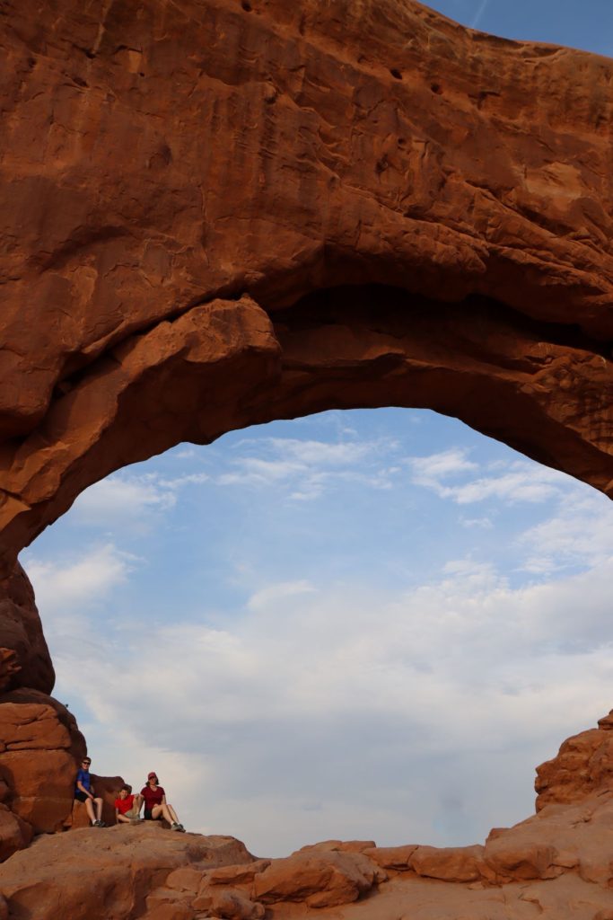 Sitting under a huge arch at Arches National Park, Utah