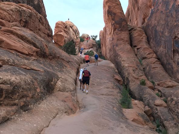 Walking up the fin on Devils Garden Trail at Arches National Park, Utah